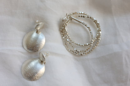 The Minimal Statement Set — round frosted earrings and beaded necklace arranged on fabric
