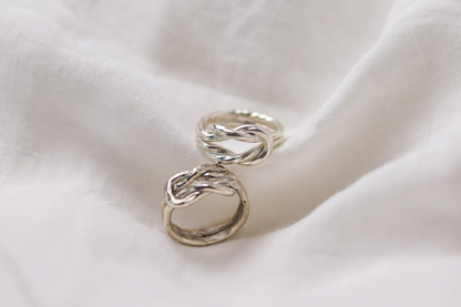 Handcrafted The Knot Ring — two knot rings arranged on fabric