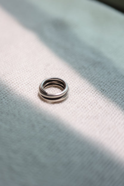 Handcrafted Silver Ring-The Loop — top view on fabric in sunlight