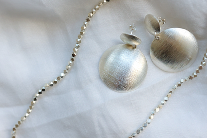 The Minimal Statement Set — close-up of frosted earrings with necklace
