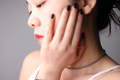 Handwoven Silver Set — model wearing black cord and silver-bead necklace