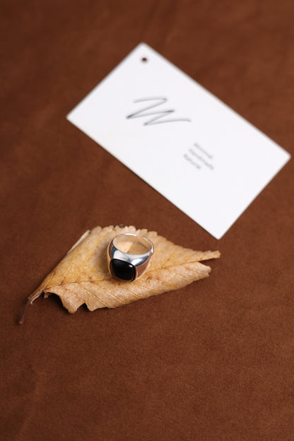 The Smoky Quartz Signet Ring — dark-stone signet ring on dried leaf