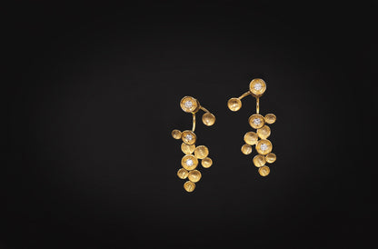 The Stars-Earrings — gold-tone star earrings on a dark background