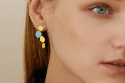 The Stones-Earrings — close-up of gold-tone drop earring worn on an ear