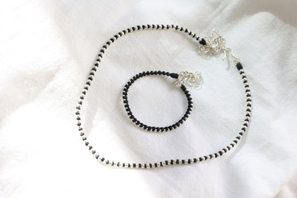 Handwoven Silver Set — necklace and bracelet arranged in loops on fabric