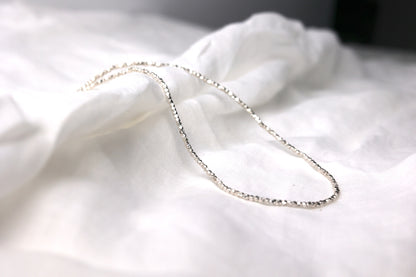 Minimalist Handcrafted Silver Beaded Necklace-Thick — beaded chain arranged on pale fabric
