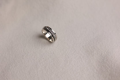 The Circles-Ring — textured spinning ring on pale fabric