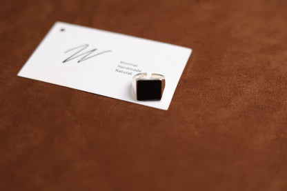 The Square Signet Ring with Black Onyx — angled view of square black-stone signet ring