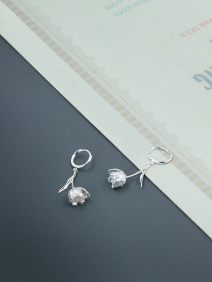 The Tulips-Earrings — silver-tone tulip earrings on grey surface