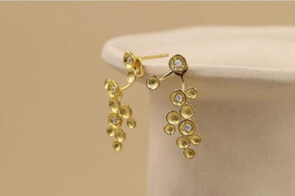 The Stars-Earrings — gold-tone star earrings on a plate rim