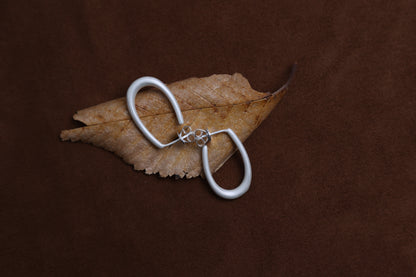 The Minimal U Ear Hoops — U-shaped hoops on dried leaf