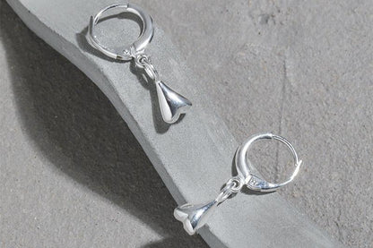 The Little Water Drop-Ear Hoop — silver-tone hoops with drop pendants on a grey block