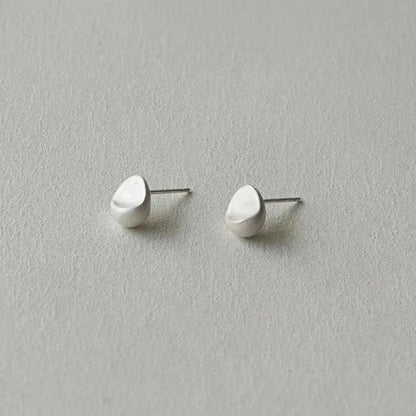 The Water Drops-Minimal Ear Stud — pair of water-drop studs on pale surface