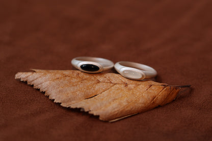 The B & W Onyx Ring — black and white oval rings on a dried leaf