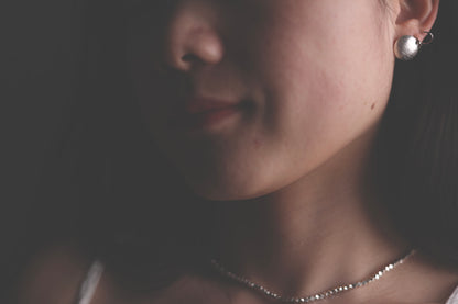 Model wearing necklace with silver earrings
