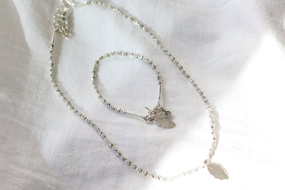 The Leaf Set — leaf-pendant beaded necklace and bracelet on fabric