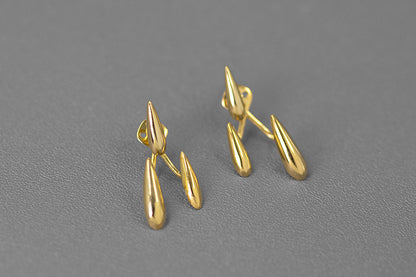 Rain Drops Earrings — pair of gold-tone drop earrings on grey surface