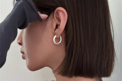 The Minimalist Basic Hoop — round hoop earring worn on an ear