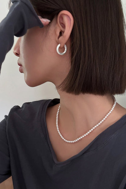 The Minimalist Basic Hoop — model wearing hoop earring with necklace