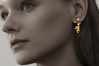 The Stars-Earrings — gold-tone star drop earring worn on an ear