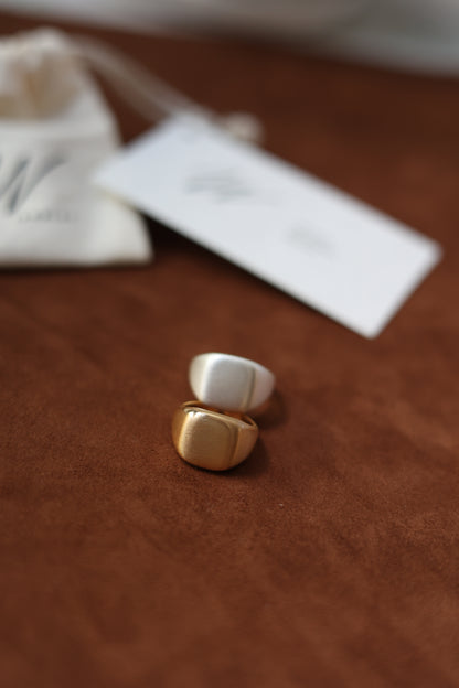 The Minimal Signet Ring — two signet rings beside branded pouch
