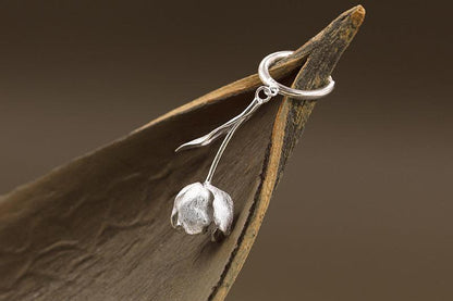 The Tulips-Earrings — silver-tone tulip earring hanging from a leaf