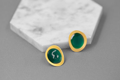 The Color Drop-Earrings — green oval earrings beside a white stone