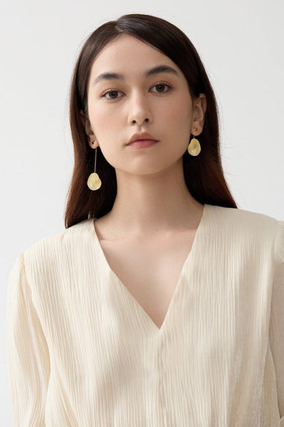 The Dune — model wearing gold-tone oval drop earrings