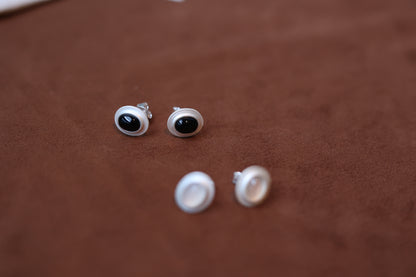The Classic B & W Onyx Ear Stud — close-up black and white studs on brown surface