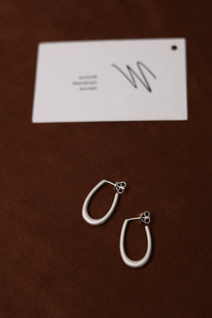 The Minimal U Ear Hoops — U-shaped hoops beside branded card