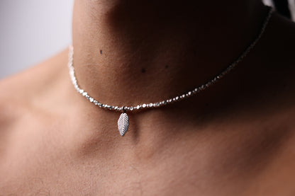 The Leaf Set — close-up of leaf-pendant necklace worn around the neck