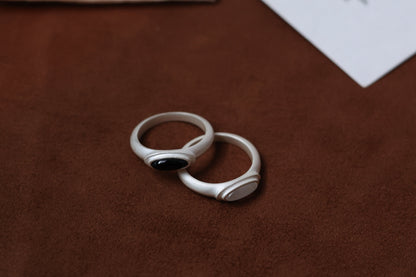 The B & W Onyx Ring — black and white oval rings on brown surface