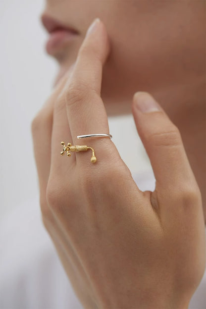 The Tab-Ring — gold-tone tap ring worn on a hand