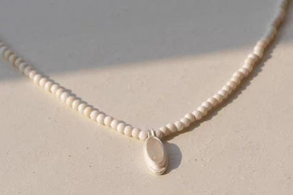 The White- Stone Necklace — beaded necklace with white oval pendant, close-up