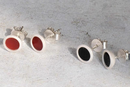 The B & R Agate Ear Stud — round red and black ear studs on textured surface