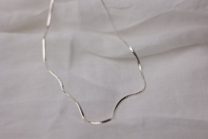 Handcrafted Minimalist Basic Silver Chain Necklace — smooth chain necklace arranged on pale fabric