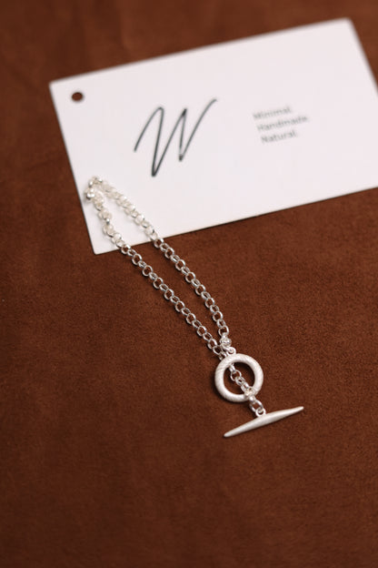 Handcrafted The Minimalist Basic Bracelet — chain bracelet with clasp on brown surface