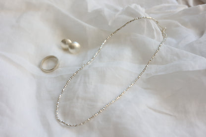 The Minimalist Set — close-up of beaded necklace, studs and ring