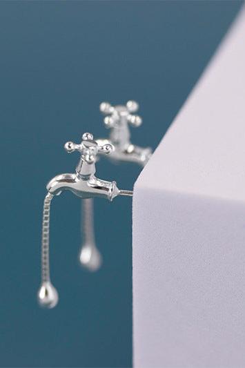 The Tab- Earrings — silver-tone tap-shaped earrings on a display
