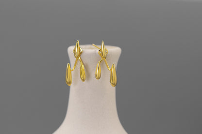 Rain Drops Earrings — gold-tone drop earrings on a display stand