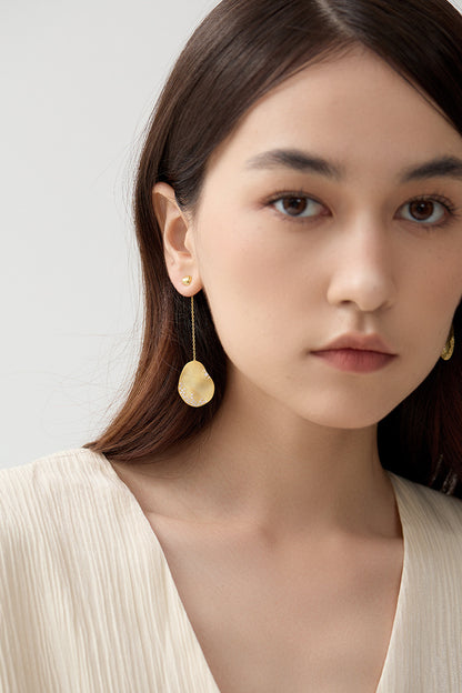 The Dune — front view of model wearing gold-tone oval drop earrings