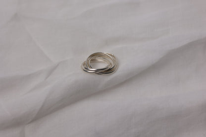 Handcrafted Interlocked Round Silver Ring — interlocked bands on pale fabric