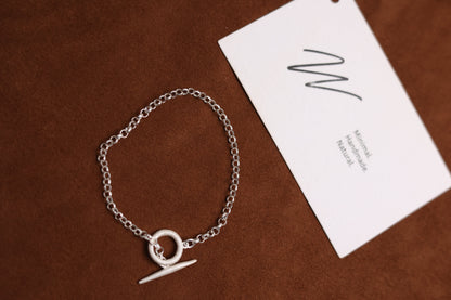 Handcrafted The Minimalist Basic Bracelet — chain bracelet arranged beside branded card
