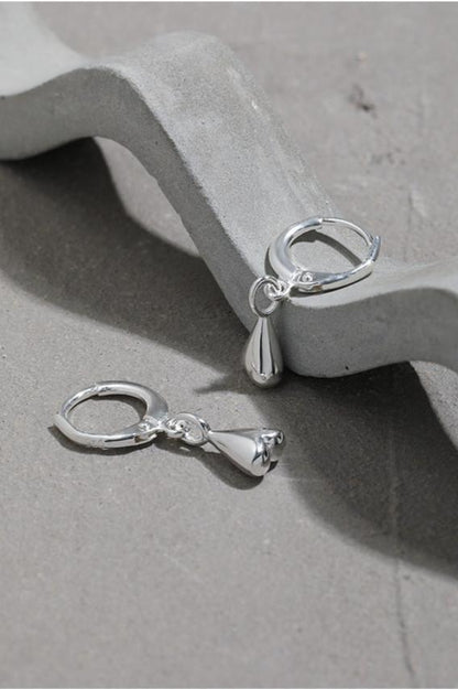 The Little Water Drop-Ear Hoop — hoops with drop pendants arranged beside a block