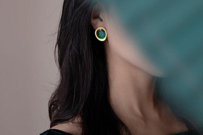The Color Drop-Earrings — green oval earring with gold-tone border worn on an ear