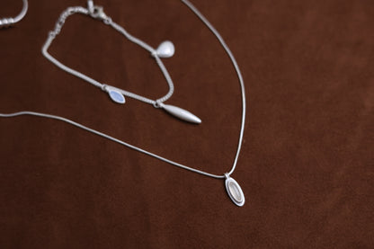 The Onyx Set- Necklace & Bracelet — necklace and bracelet set arranged on brown surface