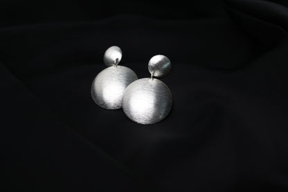 Handcrafted Frosted Minimalist Statement Earrings — pair of round drop earrings on black fabric