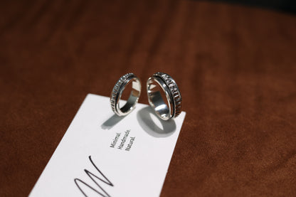 The Circles-Ring — two textured spinning rings beside branded card