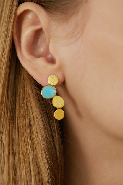 The Stones-Earrings — close-up of gold-tone drop earring with blue accent