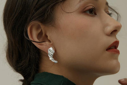The Origami-Earrings — silver-tone folded earring worn on an ear